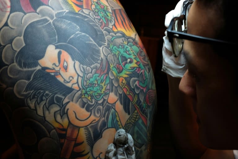 Bobo Chen inspects the inked back of his client Micky Peng in Taipei