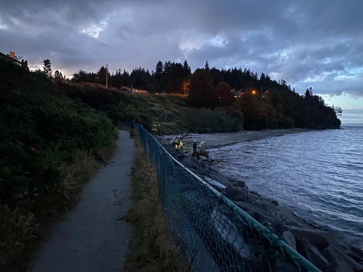 North Kitsap Fire and Rescue responders work on a beach near the Kingston Ferry Terminal to free a woman on Wednesday, June 22, 2022.