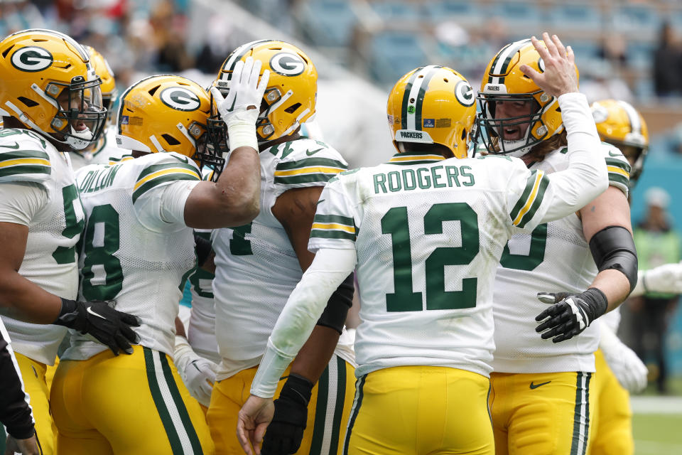 Green Bay Packers celebrate a touchdown by Green Bay Packers running back AJ Dillon (28), second left, during the second half of an NFL football game against the Miami Dolphins, Sunday, Dec. 25, 2022, in Miami Gardens, Fla. (AP Photo/Rhona Wise)