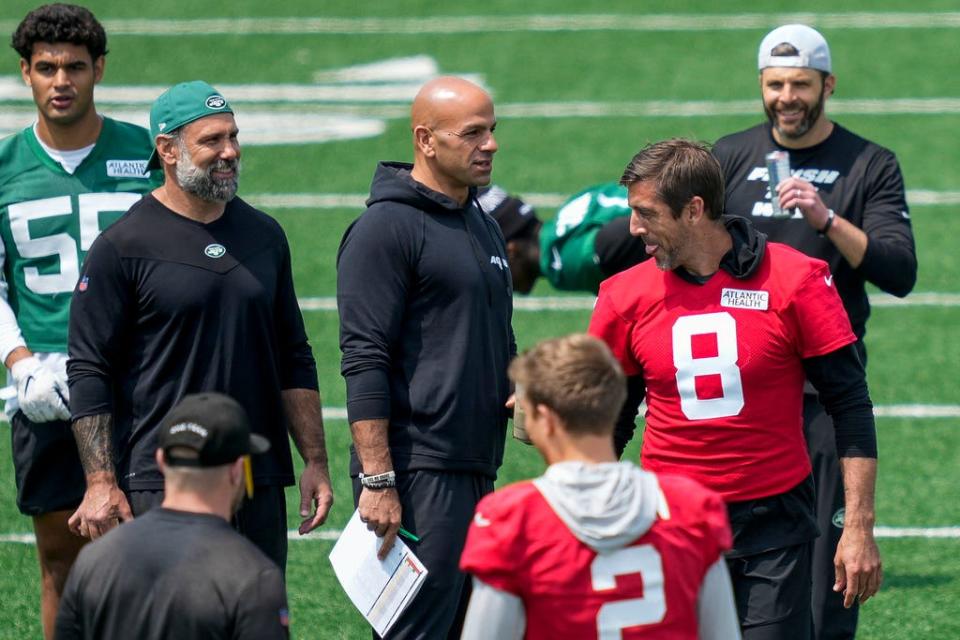 New York Jets quarterback Aaron Rodgers (8) performs stretching drills as head coach Robert Saleh, center, looks on at the NFL football team's practice facility, Tuesday, May 23, 2023, in Florham Park, N.J. (AP Photo/John Minchillo)