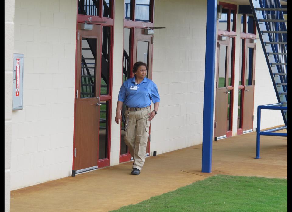 A guard walks by rooms at a new civil detention facility for low-risk inmates in Karnes City, Texas, on Tuesday, March 13, 2012. Federal officials are holding up the new facility as the centerpiece of an initiative to treat those facing immigration violation charges more humanely after lawsuits filed in past years. (AP Photo/Will Weissert)