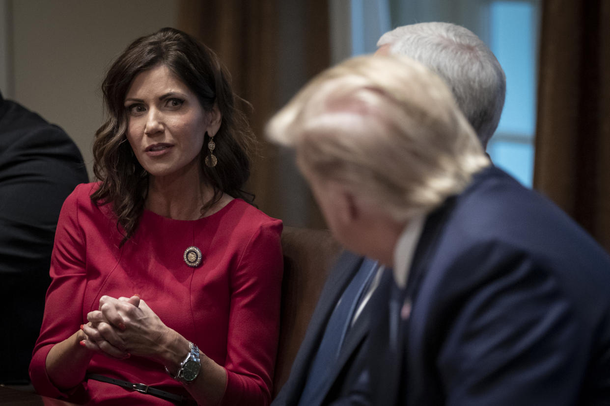 (L-R) Governor of South Dakota Kristi Noem speaks as U.S. President Donald Trump listens during a meeting about the Governors Initiative on Regulatory Innovation in the Cabinet Room of the White House on December 16, 2019 in Washington, DC. (Drew Angerer/Getty Images)