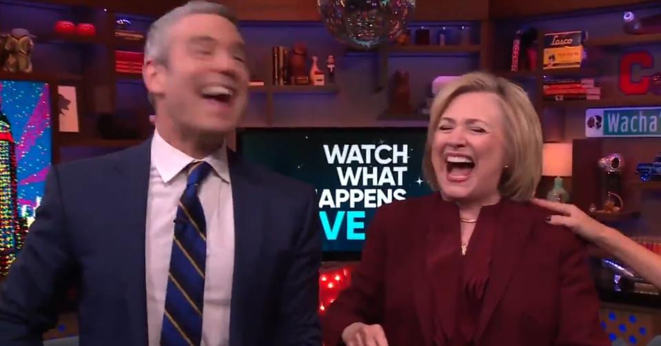 Andy Cohen and Hillary Clinton laughing after taking a shot together