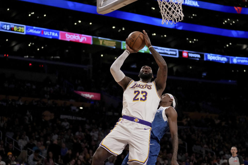 Los Angeles Lakers forward LeBron James (23) drives to the basket against Minnesota Timberwolves forward Jaden McDaniels, center right, during the first half of an NBA basketball game in Los Angeles, Sunday, March 10, 2024. (AP Photo/Eric Thayer)