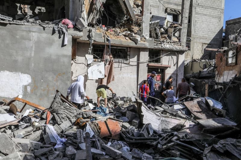 Palestinians inspect the destruction caused by an Israeli air strike that killed at least ten people and injured others. Abed Rahim Khatib/dpa