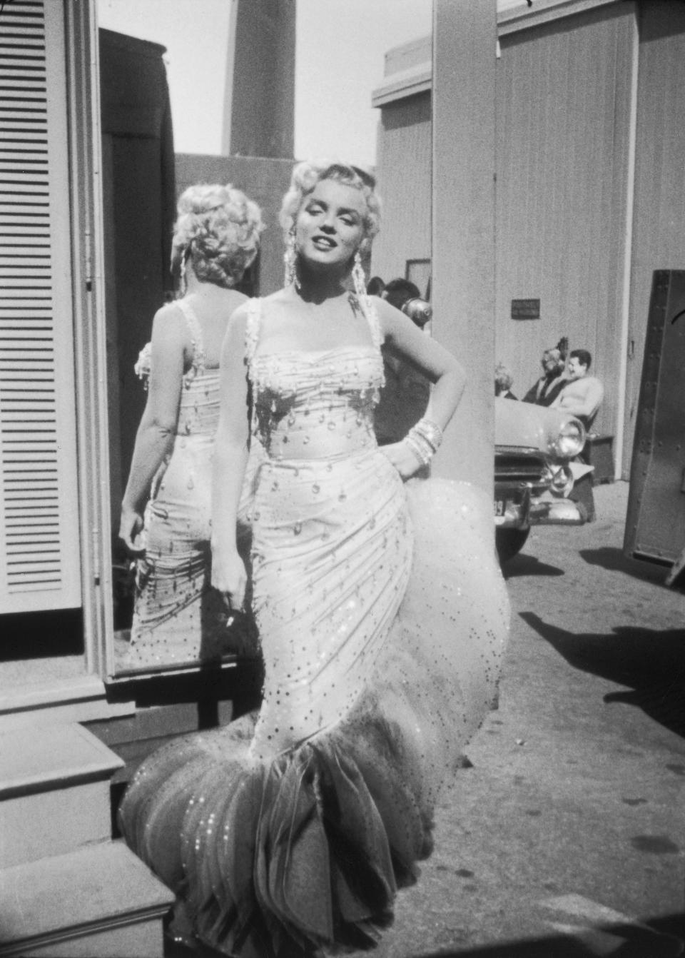 Marilyn Monroe (1926 - 1962) posing in a white beaded gown, on the set of "There's No Business Like Show Business."