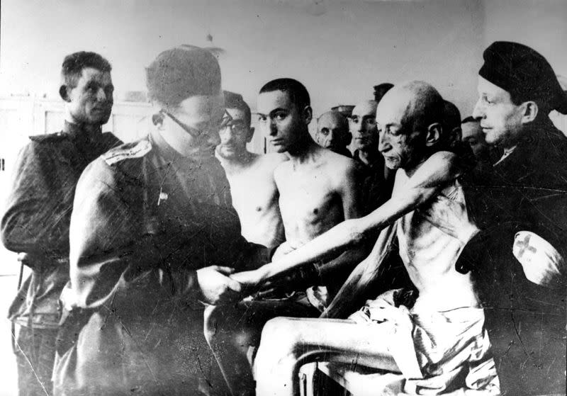 Soviet military doctor examines Holocaust survivors after the liberation of the Nazi German death camp Auschwitz-Birkenau in Nazi-occupied Poland, in this undated handout picture