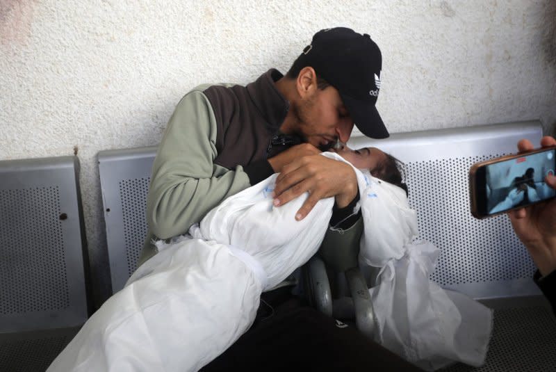 A Palestinian man hugs the lifeless body of his child killed in an Israeli attack on Ridwan family house, at Al-najar Hospital in Rafah, southern Gaza, on Saturday on April 20, 2024. An Israeli attack on Ridwan family house, leaving many injured and at least 9 dead including 6 children and tow women, Medical sources said. Photo by Ismael Mohamad/UPI