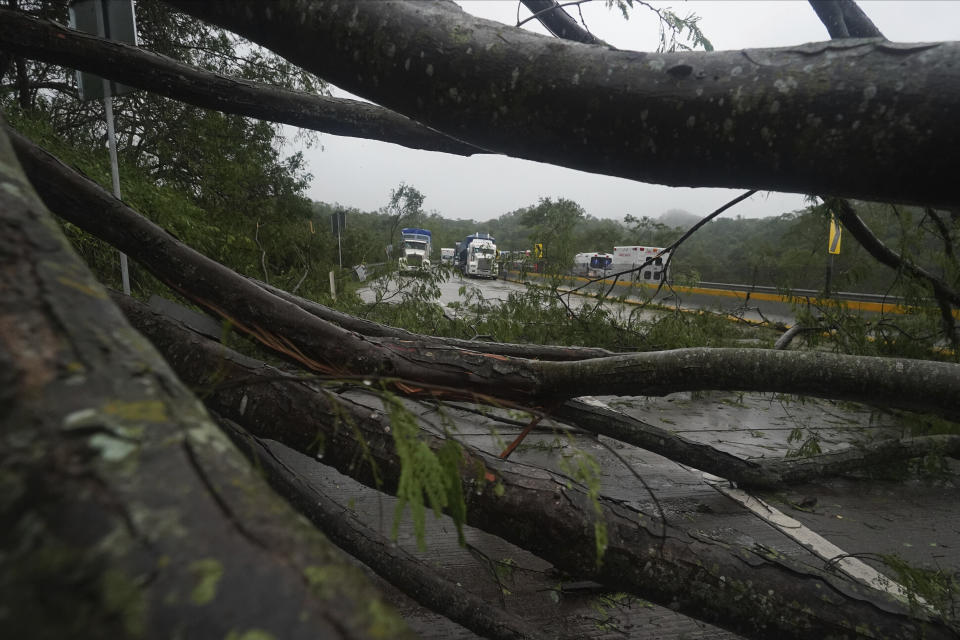 FILE - Trucks sit idle on a highway blocked by a landslide triggered by Hurricane Otis near Acapulco, Mexico, Wednesday, Oct. 25, 2023. The hurricane turned from mild to monster in record time, and scientists are struggling to figure out how — and why they didn't see it coming. (AP Photo/Marco Ugarte, File)