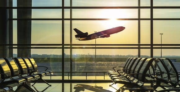 An airplane taking off out of the view of a terminal.