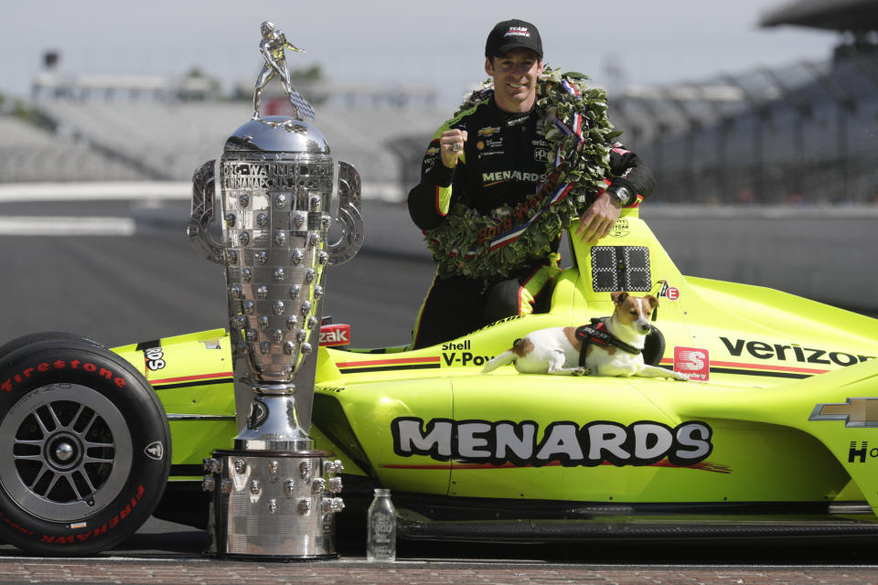 Simon Pagenaud, of France, winner of the 2019 Indianapolis 500 auto race, poses with his dog Norman during the traditional winners photo session at the Indianapolis Motor Speedway in Indianapolis, Monday, May 27, 2019. (AP Photo/Michael Conroy)
