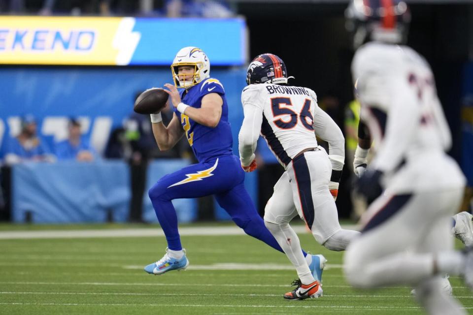 Chargers quarterback Easton Stick is chased by Broncos linebacker Baron Browning