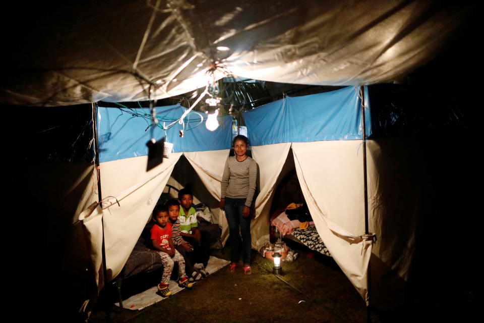 <p>Veronica Dircio, 34, a housewife, poses for a portrait with her sons in front of a tent in a neighbour’s backyard after an earthquake in San Juan Pilcaya, at the epicentre zone, Mexico, September 28, 2017. Dircio’s house was badly damaged. “We stayed on the street. We expect the demolition of our house and the help of the authorities,” she said. (Photo: Edgard Garrido/Reuters) </p>
