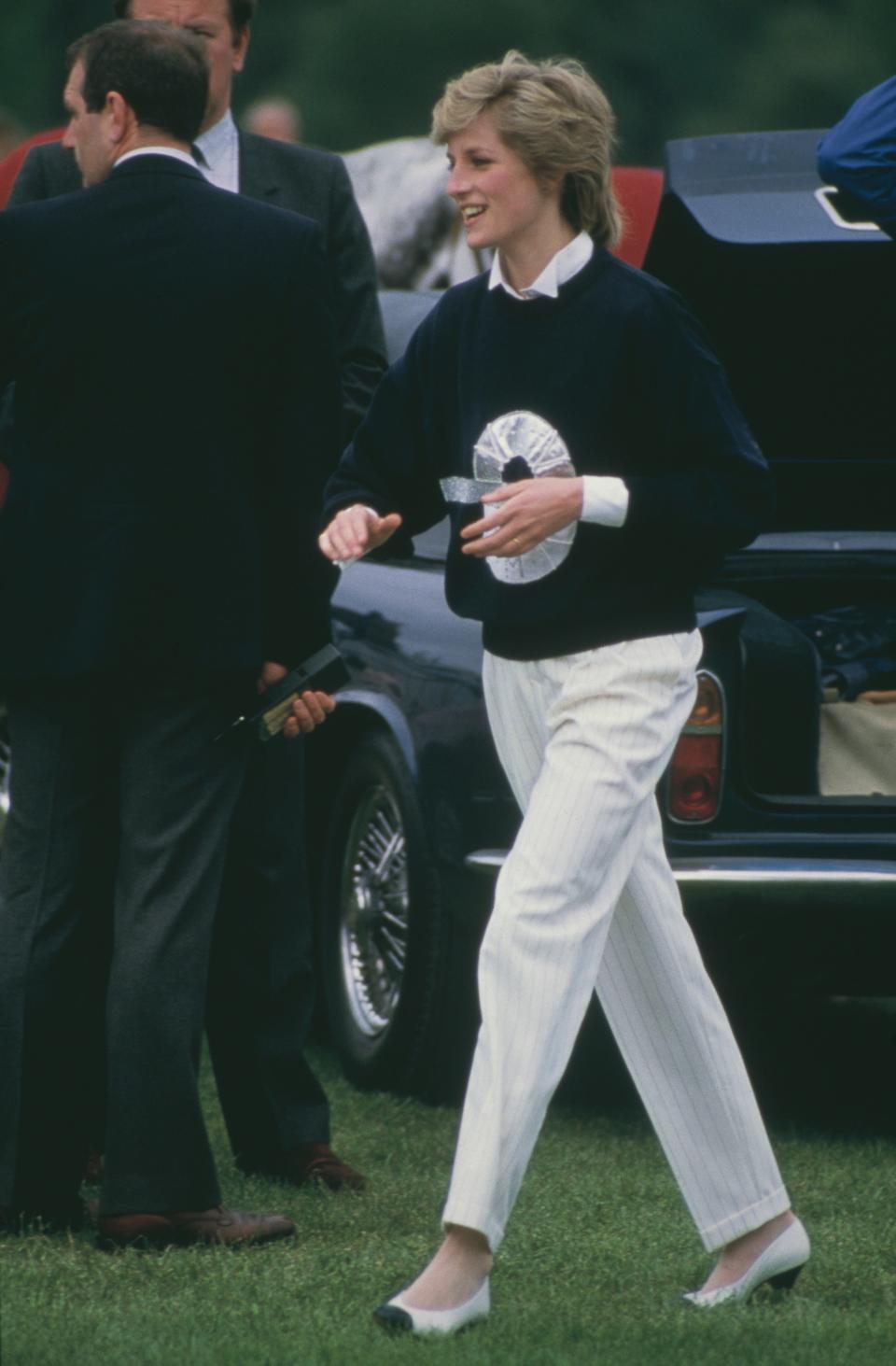 princess diana in a navy sweater and white slacks