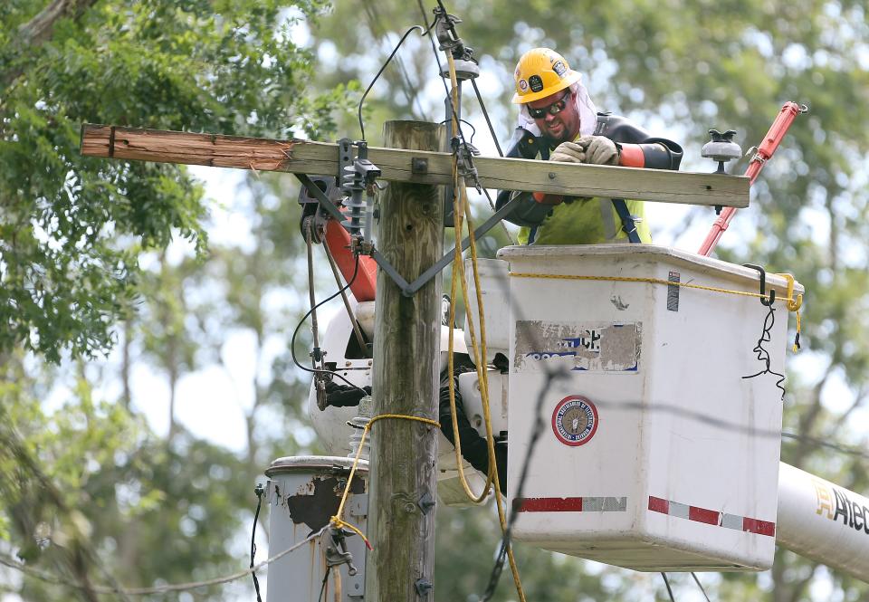 A National Grid lineman repairs a damaged power pole in Wakefield after Tropical Storm Henri blew through last August.