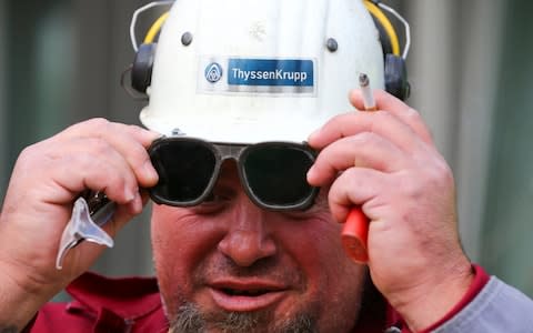 A steel worker takes off his heat-resistant goggles following his shift at the ThyssenKrupp AG steel plant in Duisburg - Credit: Reuters