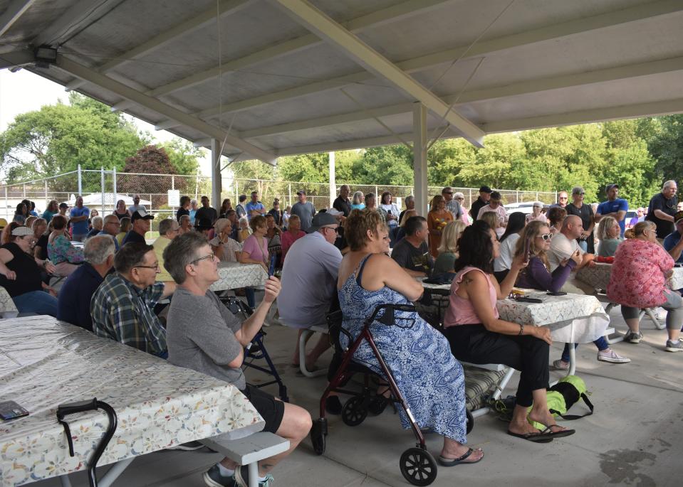 People gather inside the pavilion at Deerfield's community park Friday, Aug. 11, 2023, to be part of the ribbon-cutting unveiling ceremony of the village's new commemorative brick walk.