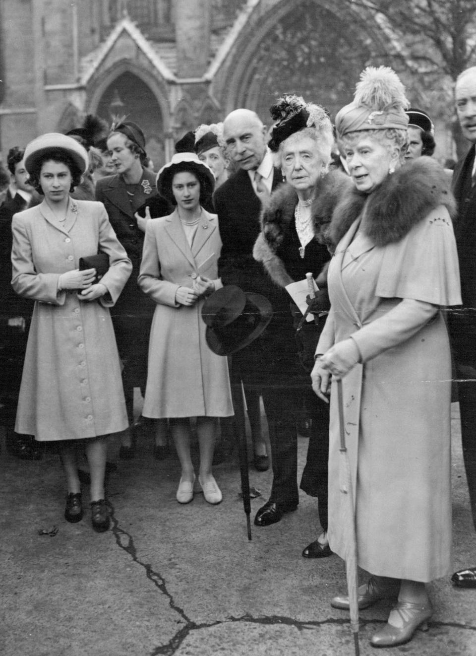 Princess Elizabeth, Princess Margaret, the Earl of Athlone, Mabell, Countess of Airlie, and Queen Mary watch the bridal procession at the Butters' wedding - SuperStock/Alamy