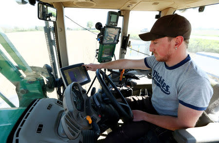 An employee of the "Poschinger Bray'sche Gueterverwaltung" company controls a tractor equipped with an iTC receiver (used for parallel driving) at a field in Irlbach near Deggendorf, Germany, April 21, 2016. REUTERS/Michaela Rehle