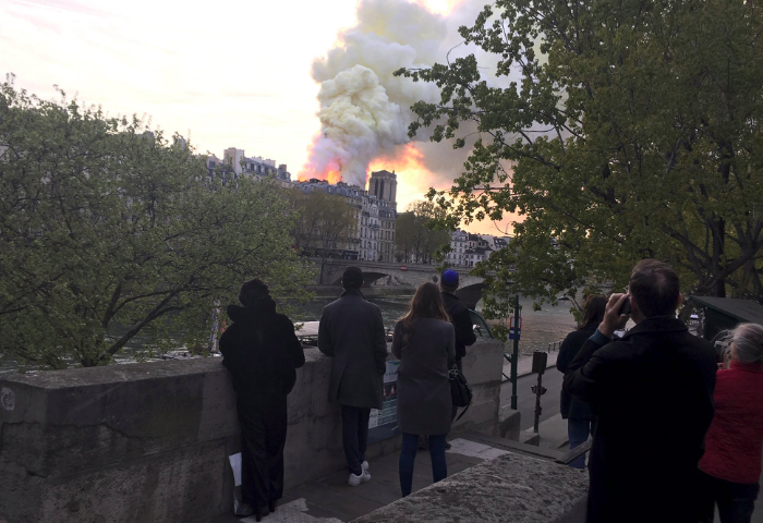 Parisians watch on in horror. Thousands lined the streets to catch a glimpse of the damage into the night. Source: AP