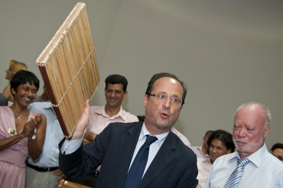 French Socialist party candidate for the presidential elections Francois Hollande, center, holds a Kayam, a local musical instrument, given as a gift as he visits Saint-Benoit, in La Reunion island, Sunday, April 1, 2012. Hollande is on a two-day visit to the French island of the Indian Ocean. (AP Photo/Fabrice Wislez)