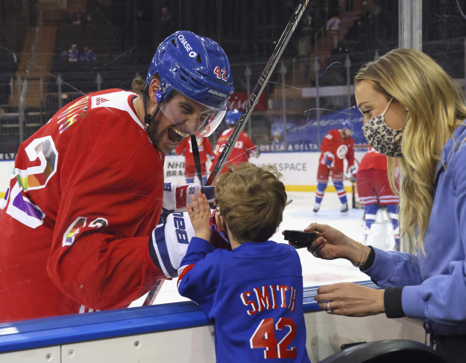 New York Rangers' Brendan Smith (42) says hello to his son Nolan and wife Samantha during warmups prior to an NHL hockey game against the Washington Capitals in New York, Monday, May 3, 2021. (Bruce Bennett/Pool Photo via AP)