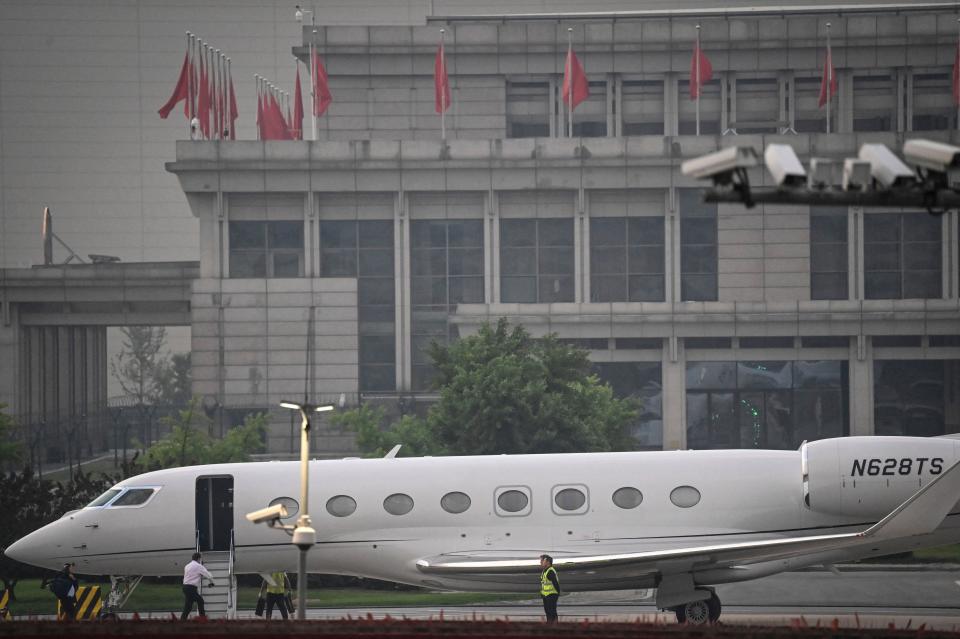 Tesla Chief Executive Officer Elon Musk (in white) boards his private jet before departing from Beijing Capital International Airport on May 31, 2023