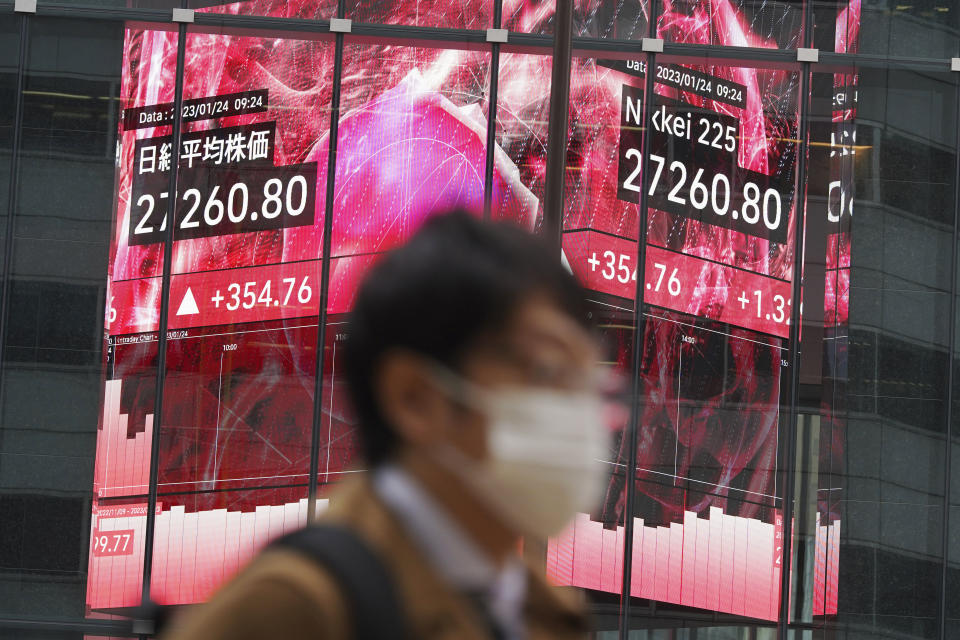 A person walks in front of an electronic stock board showing Japan's Nikkei 225 index at a securities firm Tuesday, Jan. 24, 2023, in Tokyo. Stocks were higher in Asia on Tuesday after a tech-led rally on Wall Street as investors bet the Federal Reserve will trim its rate hikes to tamp down inflation. (AP Photo/Eugene Hoshiko)