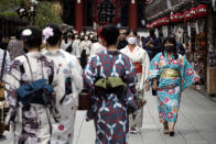 People wearing protective masks to help curb the spread of the coronavirus walk at shopping arcade at Asakusa district Tuesday, Sept. 29, 2020, in Tokyo. The Japanese capital confirmed more than 200 coronavirus cases on Tuesday. (AP Photo/Eugene Hoshiko)