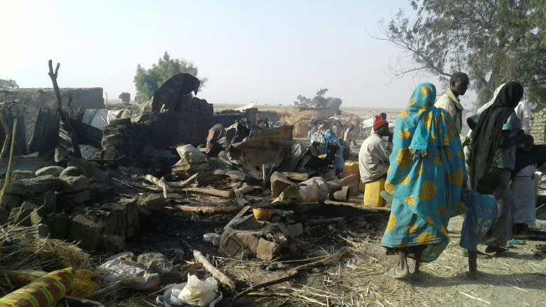 Survivors look at the aftermath of the bombing by the Nigerian air force of a camp for displaced people in Rann, northeast Nigeria, on January 17, 2017