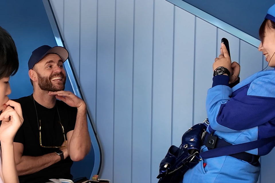 Shane Hryhorec forcing a smile while a Tokyo Disneyland employee takes his photo.