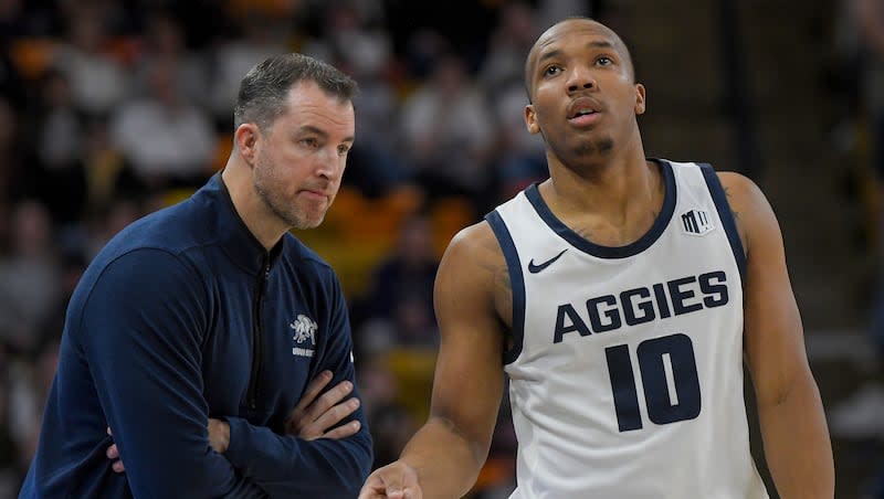 Utah State coach Danny Sprinkle talks with guard Darius Brown II during game against Wyoming, Tuesday, Jan. 9, 2024, in Logan, Utah. The first-year Aggies coach has his team flying heading into NCAA Tournament.