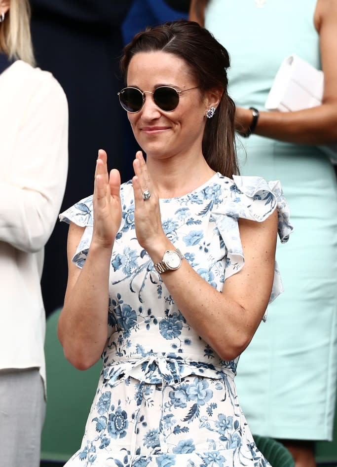 Pippa Middleton wearing a ruffly white and blue floral print dress, sunglasses and a Cartier watch at Wimbledon. - Credit: Shutterstock