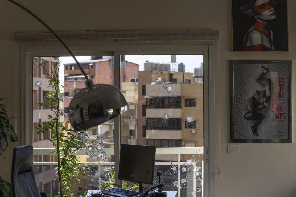 An office window is riddled with bullet holes after the deadly clashes that erupted last Thursday along a former 1975-90 civil war front-line between Muslim Shiite and Christian areas, in Ain el-Rumaneh neighborhood, Beirut, Lebanon, Tuesday, Oct. 19, 2021. The shootout on the streets of Beirut between rival Christian and Muslim groups has revived memories of the country's 1975-90 civil war and fired up sectarian passions in a country that never dealt with the causes of its violent past. (AP Photo/Hassan Ammar)