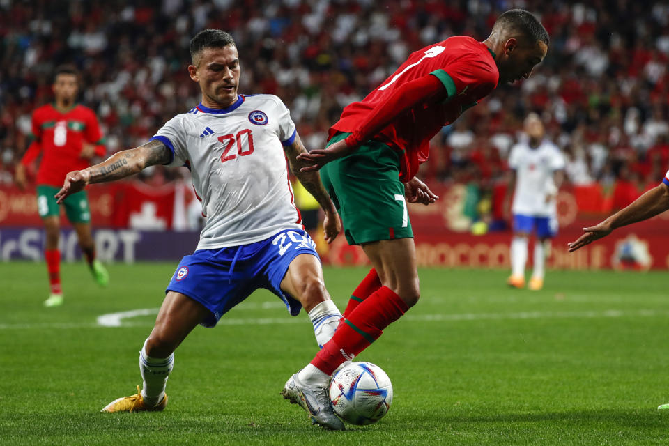 Chile's Charles Aranguiz, left, vies for the ball with Morocco's Hakim Ziyech during an international friendly soccer match between Morocco and Chile at the Cornella-El Prat stadium in Barcelona, Spain, Friday, Sept. 23, 2022. (AP Photo/Joan Monfort)