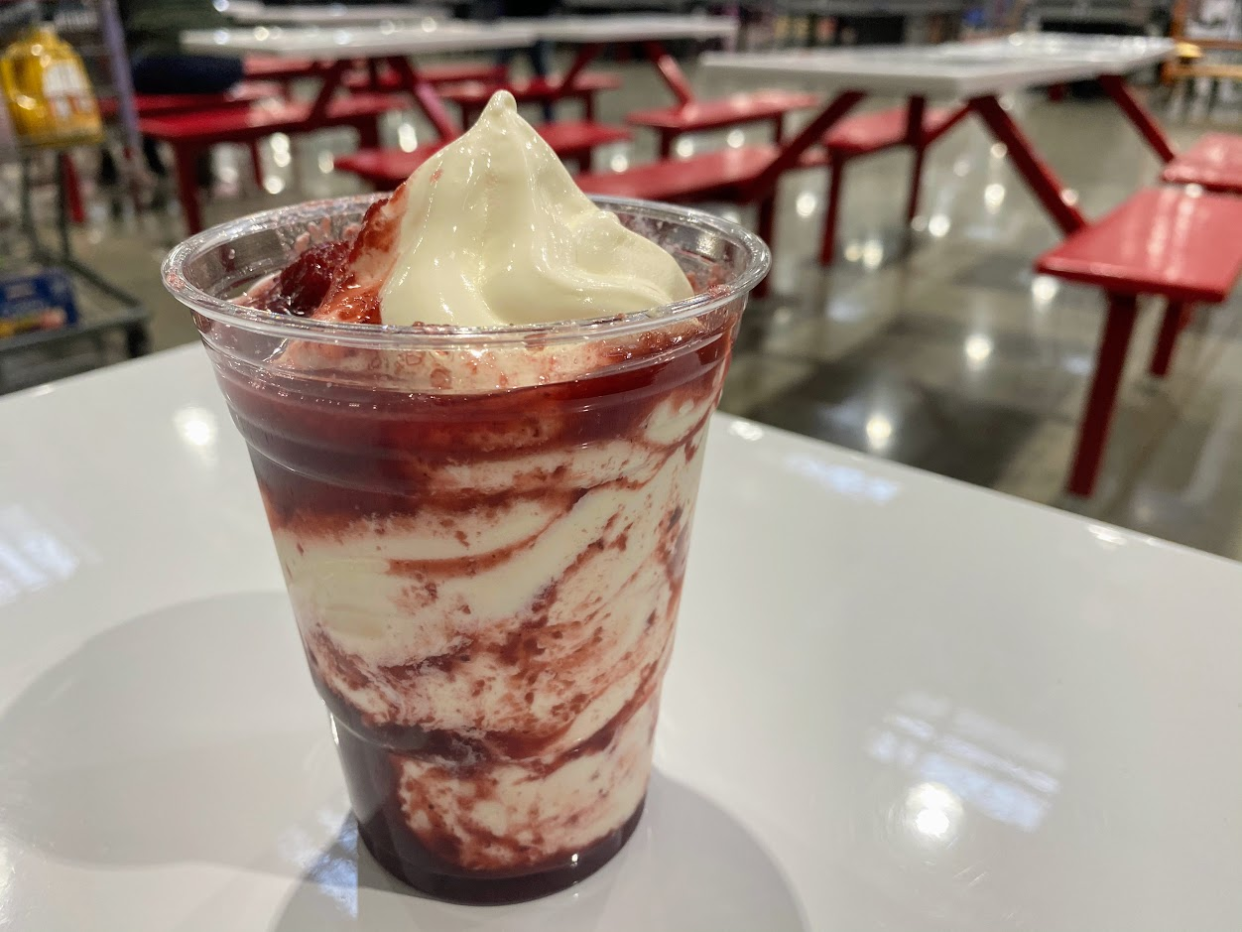 Berry sundae at the Costco food court on a white table, grey concrete floor and seating blurred in the background