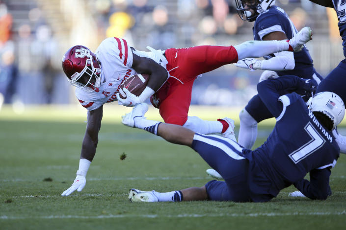 Houston running back Alton McCaskill (22) is upended by Connecticut defensive back Tre Wortham (7) during the first half of an NCAA football game, Saturday, Nov. 27, 2021, in East Hartford, Conn. (AP Photo/Stew Milne)