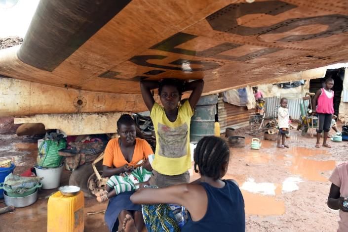 A family rests under the wing of a derelict plane on May 3, 2014 at a refugee camp at Bangui's Mpoko airport (AFP Photo/Issouf Sanogo)
