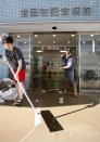 People clean a flooded hospital hit by Typhoon Hagibis, in Tokyo Sunday, Oct. 13, 2019. Rescue efforts for people stranded in flooded areas are in full force after a powerful typhoon dashed heavy rainfall and winds through a widespread area of Japan, including Tokyo.(Kyodo News via AP)