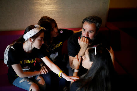 Manuel Oliver, the father of Joaquin Oliver one of the victims of the mass shooting at Marjory Stoneman Douglas High School, cries next to his family after painting a mural to commemorate the victims of the shooting and promote gun control in Los Angeles, California, U.S., April 7, 2018. REUTERS/Carlos Garcia Rawlins