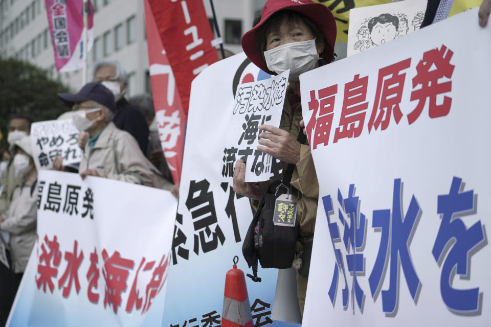 People protest against government's decision to start releasing massive amounts of treated radioactive water from the wrecked Fukushima nuclear plant into the sea, during a rally outside the prime minister's office in Tokyo Tuesday, April 13, 2021. The decision, long speculated but delayed for years due to safety concerns and protests, came at a meeting of Cabinet ministers who endorsed the ocean release as the best option. Signs mean "Don't release radioactive water into the sea." (AP Photo/Eugene Hoshiko)