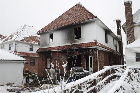 A firefighter surveys the aftermath of a home fire in the Midwood neighborhood of Brooklyn, New York March 21, 2015. REUTERS/Stephanie Keith