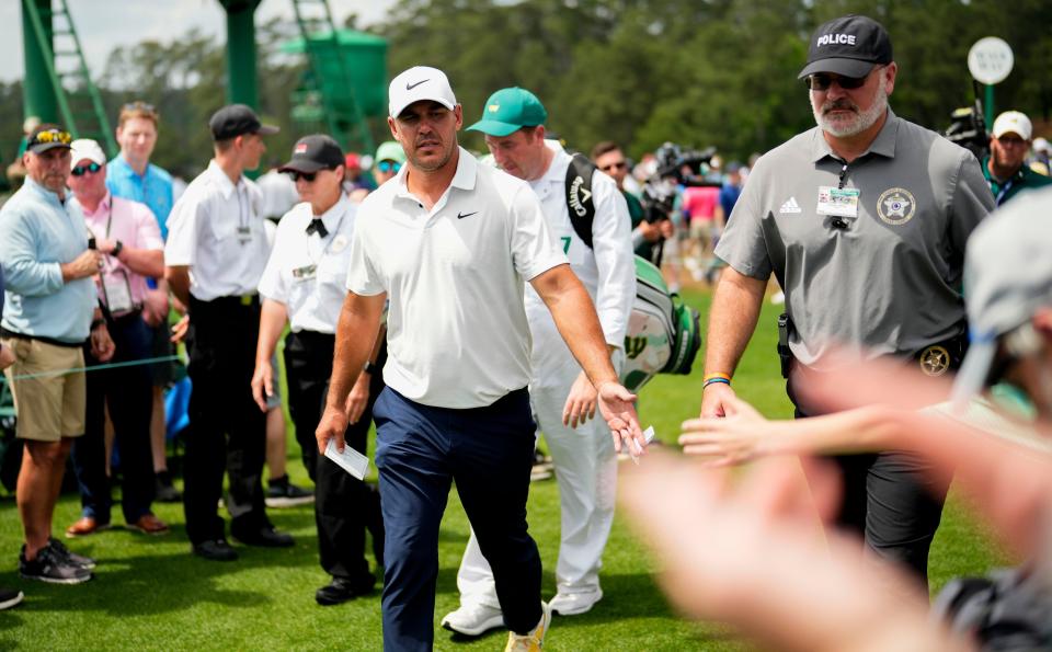 Brooks Koepka greets patrons after finishing his second round of The Masters.