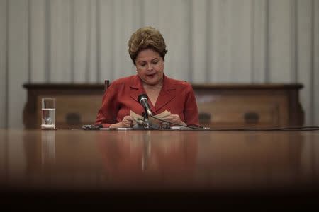 Brazil's President and Workers' Party (PT) presidential candidate Dilma Rousseff looks through papers during a news conference at Alvorada Palace in Brasilia September 26, 2014. REUTERS/Ueslei Marcelino