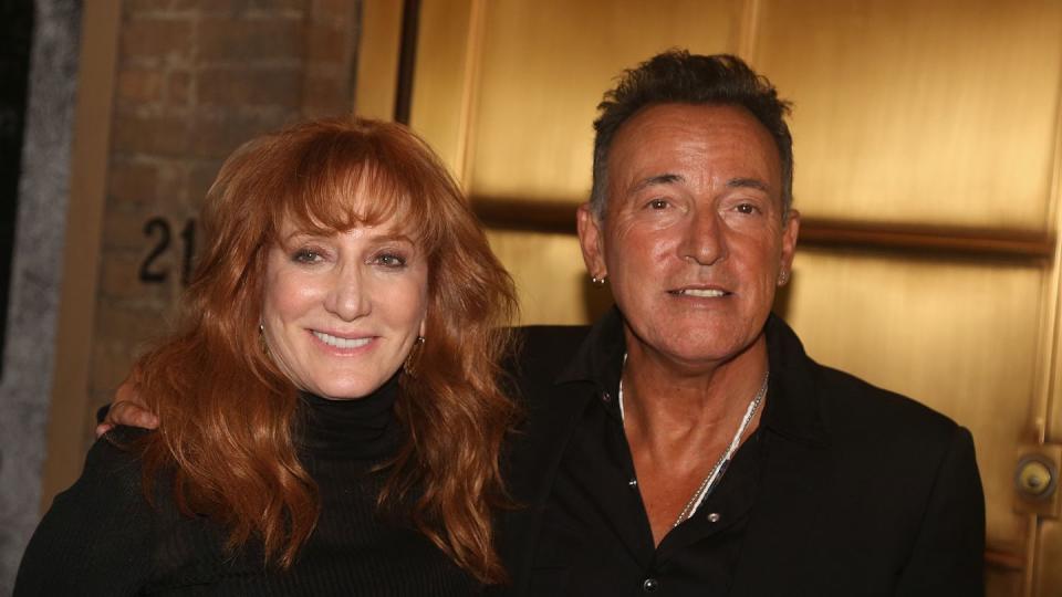 bruce springsteen embracing wife patti scialfa with his right arm with the two smiling for a photo