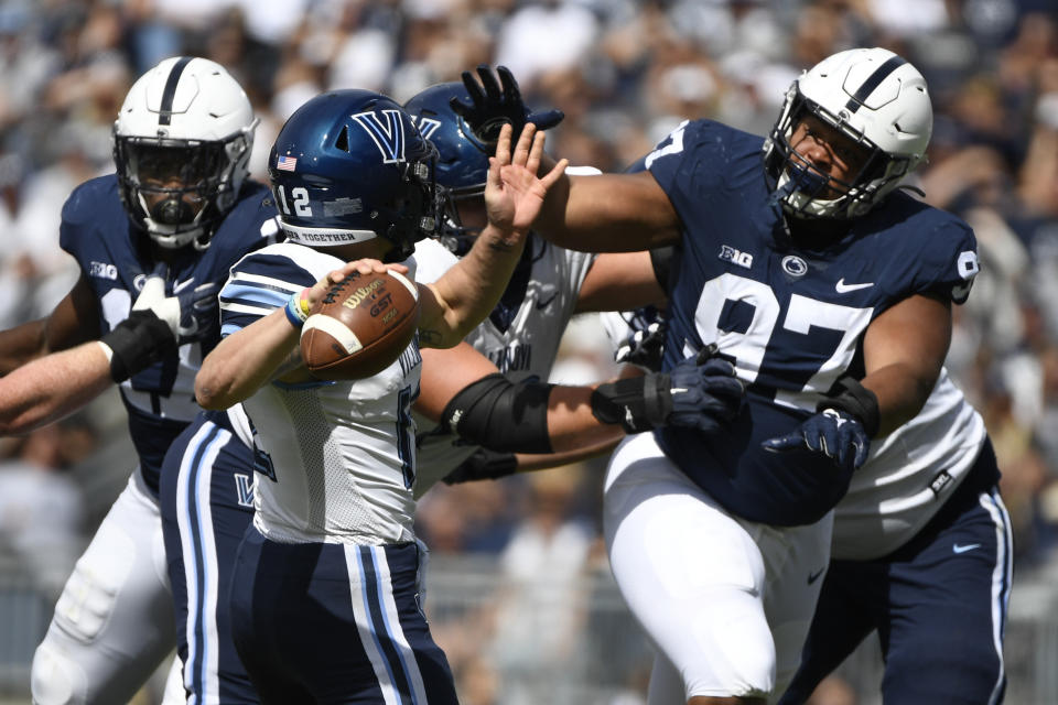 Penn State defensive tackle PJ Mustipher (97) pressures Villanova quarterback Daniel Smith (12) during an NCAA college football game in State College, Pa., on Saturday, Sept. 25, 2021. (AP Photo/Barry Reeger)