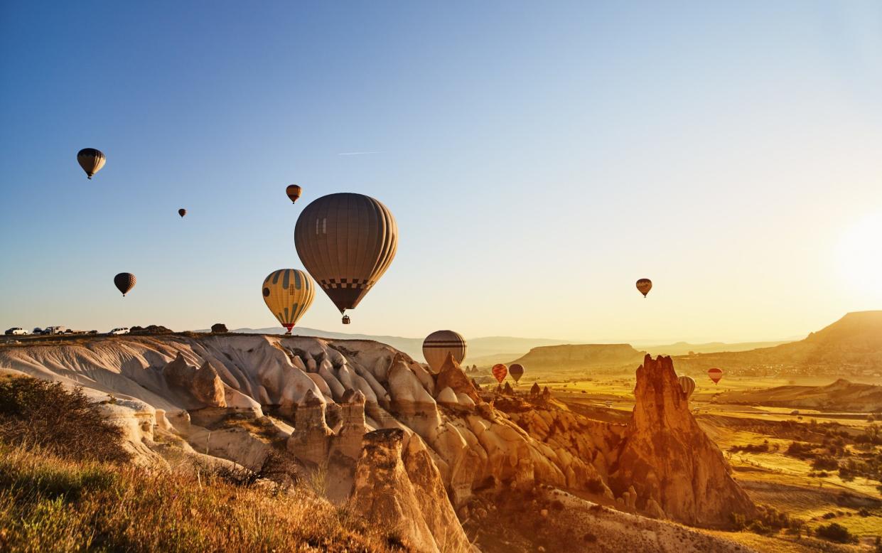 Hot air balloons flying at sunset, Cappadocia - Getty
