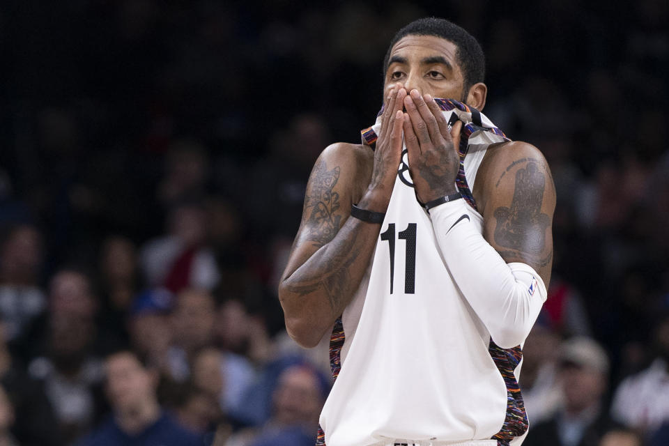 Kyrie Irving #11 of the Brooklyn Nets wipes his face against the Philadelphia 76ers in the fourth quarter at the Wells Fargo Center on January 15, 2020.