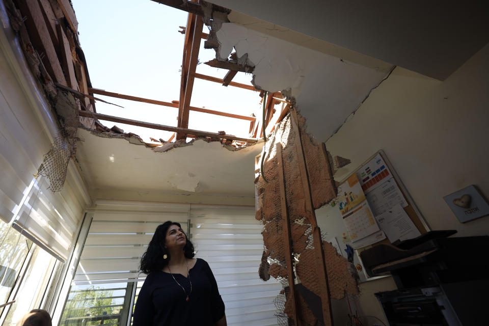 A woman looks at the damage to a house in Sderot, Israel, after it was hit by a rocket fired from Gaza Strip, Tuesday, Nov. 12m 2019. Israel has killed a senior Islamic Jihad commander in Gaza in a rare targeted killing that threatened to unleash a fierce round of cross-border violence with Palestinian militants. (AP Photo/Tsafrir Abayov)