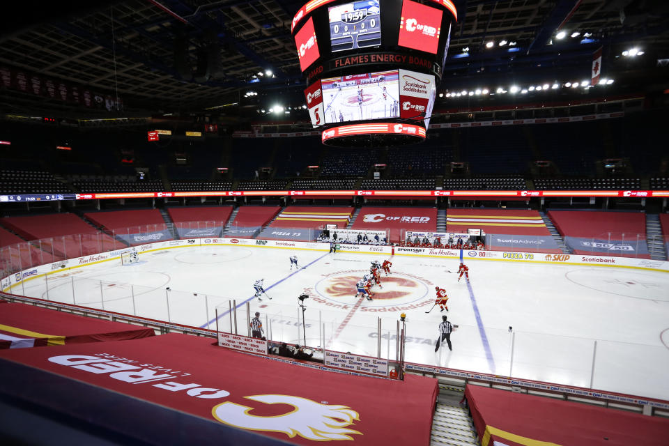 Play begins as the Vancouver Canucks and the Calgary Flames play in the Flames' home-opener NHL hockey game Saturday, Jan. 16, 2021, in Calgary, Alberta. (Jeff McIntosh/The Canadian Press via AP)